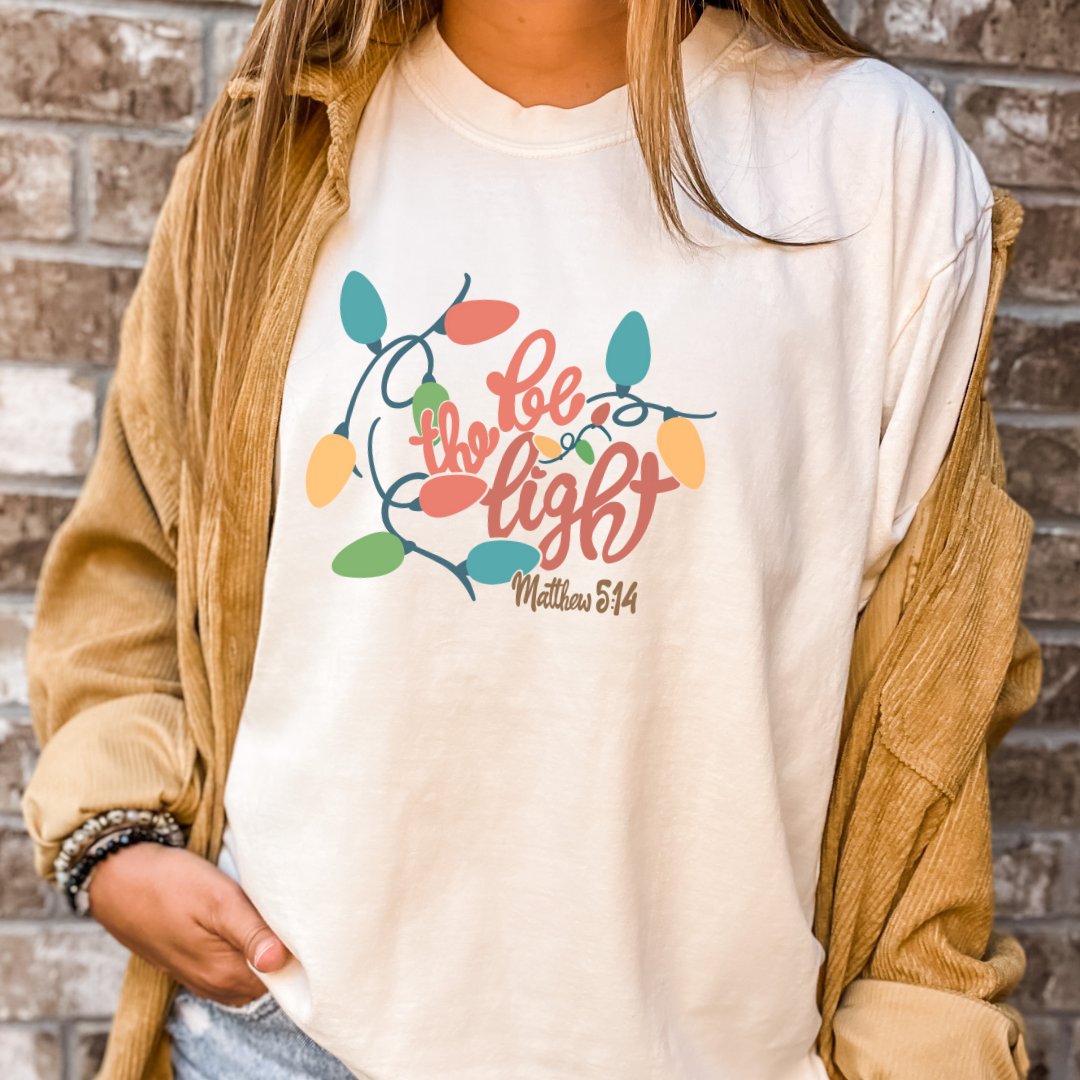 Be the Light Christmas Tee- Christmas Graphic Tshirt Hoodie, Sweatshirt | PodTeesHub.com