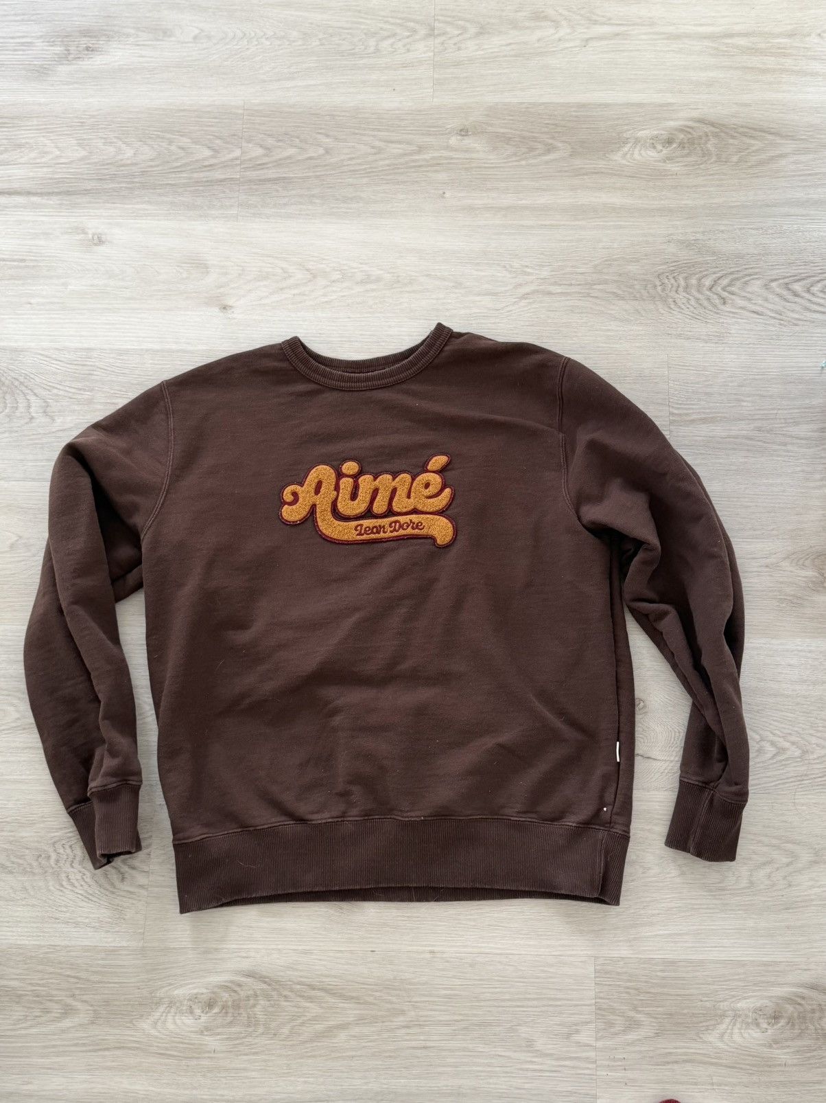 Leon Dore Aime Leon Dore Script Chenille Logo Crewneck Brown T-Shirts, Hoodie, Sweatshirt | PodTeesHub.com