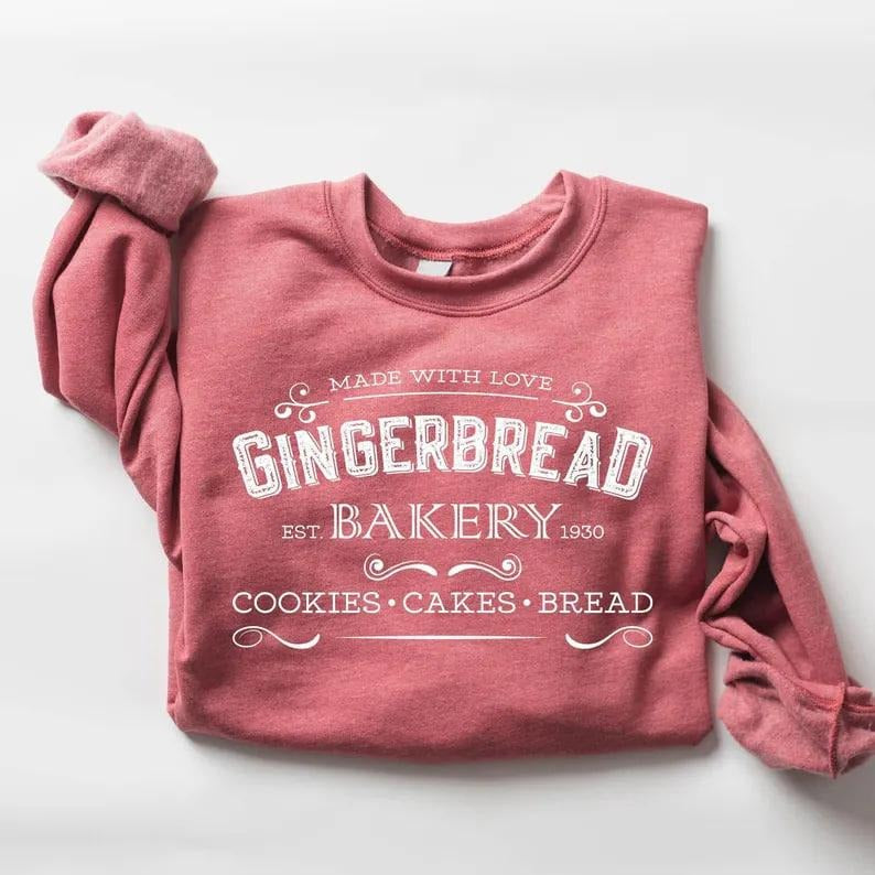Adorable Christmas sweatshirt for women featuring a retro gingerbread bakery design, festive cookies, and merry holiday...