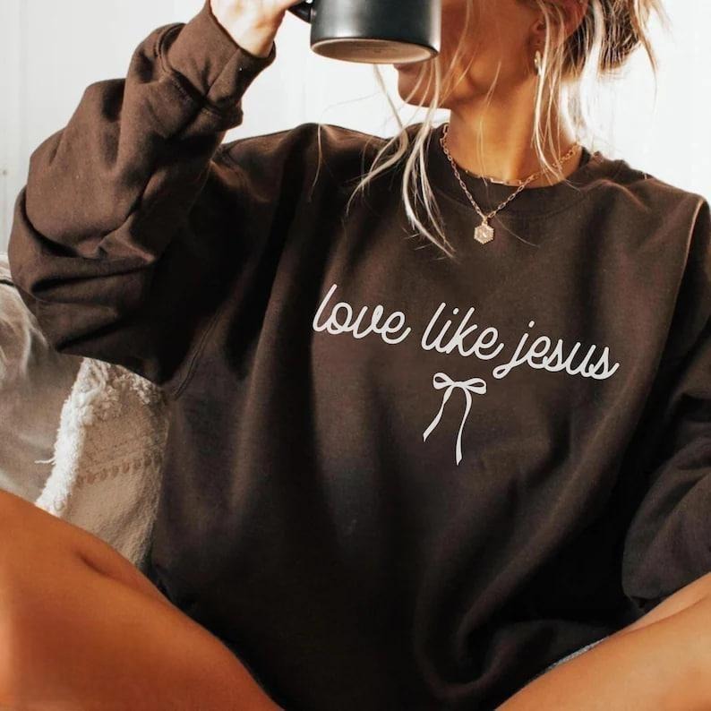 Love Like Jesus sweatshirt for women, Christian crewneck featuring aesthetic Bible verse design, cozy faith-based...