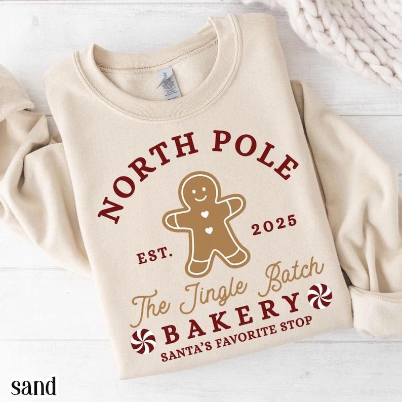 North Pole Christmas sweatshirt with gingerbread man, Santa, and Xmas lights, cozy silly holiday pullover, perfect...