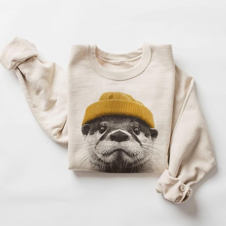 Retro River Otter Wearing Beanie Unisex Sweatshirt #DICH T-Shirts, Hoodie | PodTeesHub.com