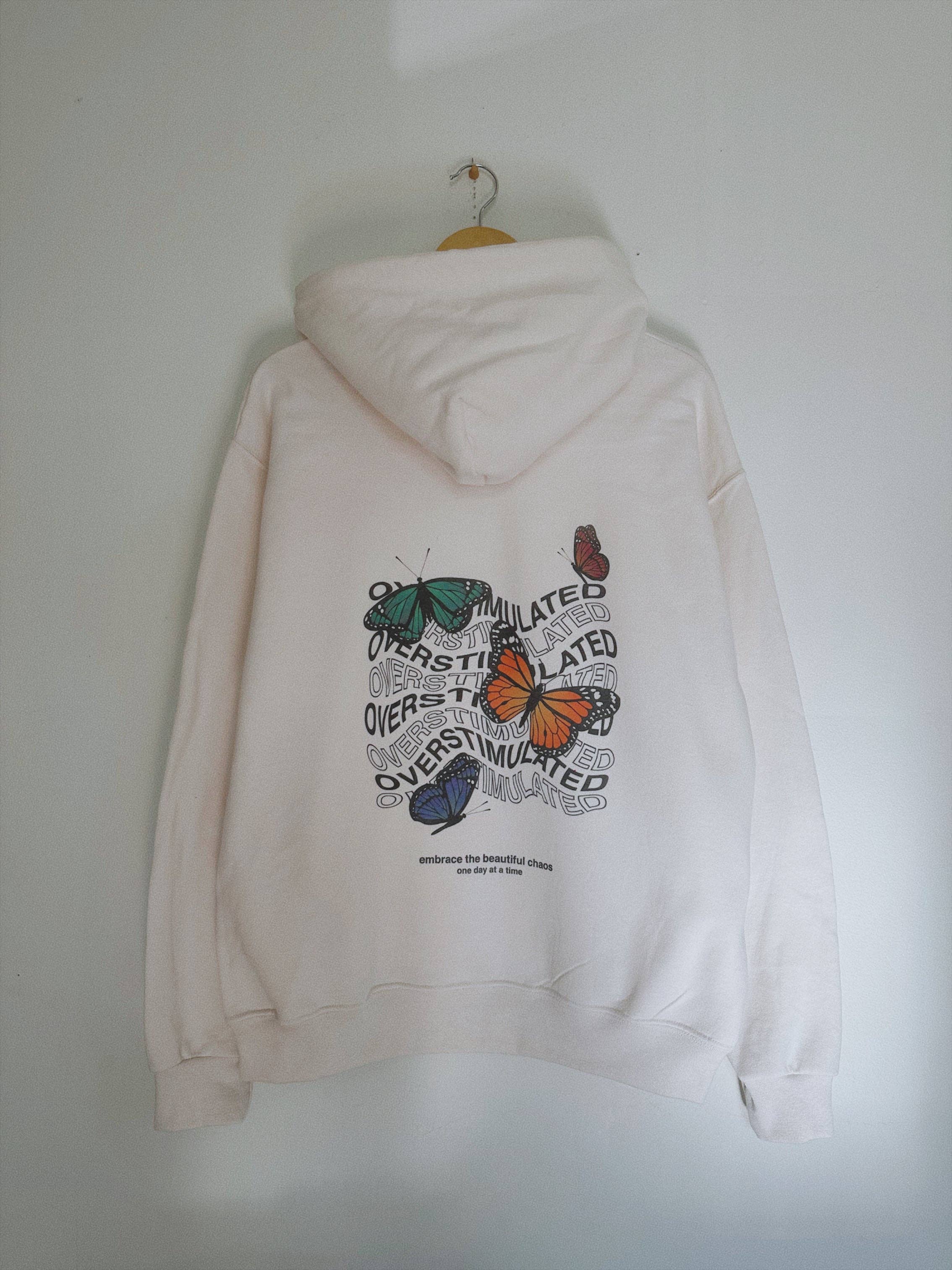 "Overstimulated" Cream Hoodie 🦋 T-Shirts, Sweatshirt | PodTeesHub.com