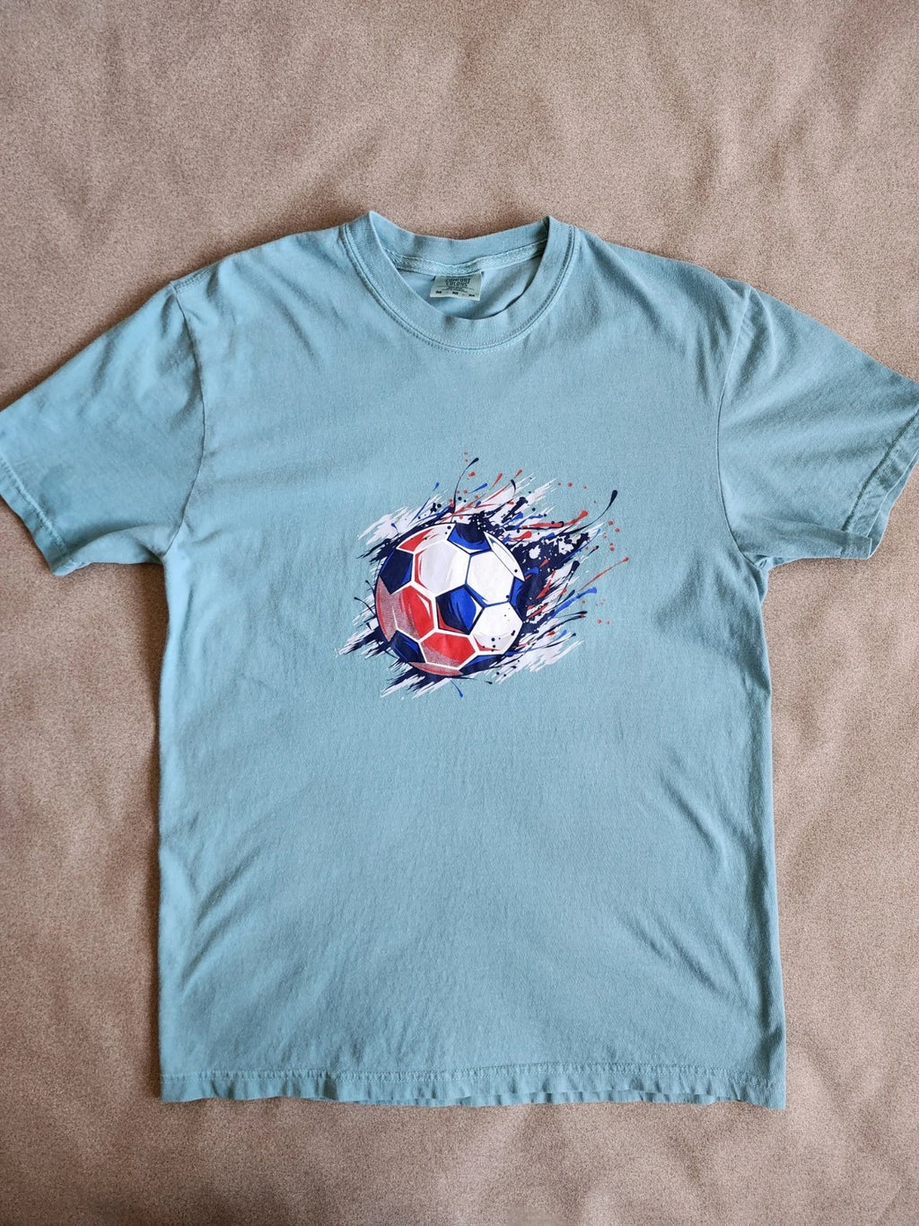 Light green short-sleeve t-shirt with soccer Ball Graphic.  Medium Size
