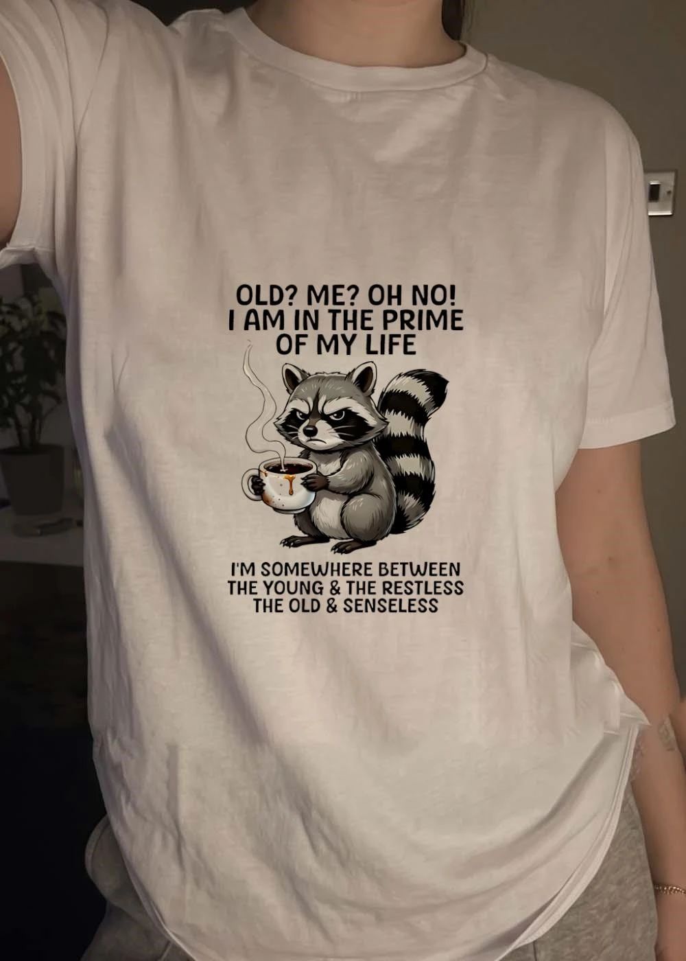 Funny Raccoon Holding Coffee Mug Old Me Oh No I Am In The Prime Of My Life I Am Somewhere Between The Young The Restless Old Senseless T-Shirt